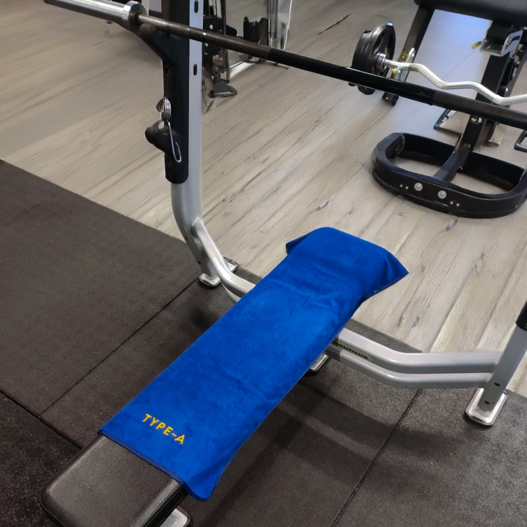 Type-A Gym Towel on a flat bench top view, showing the size and logo.